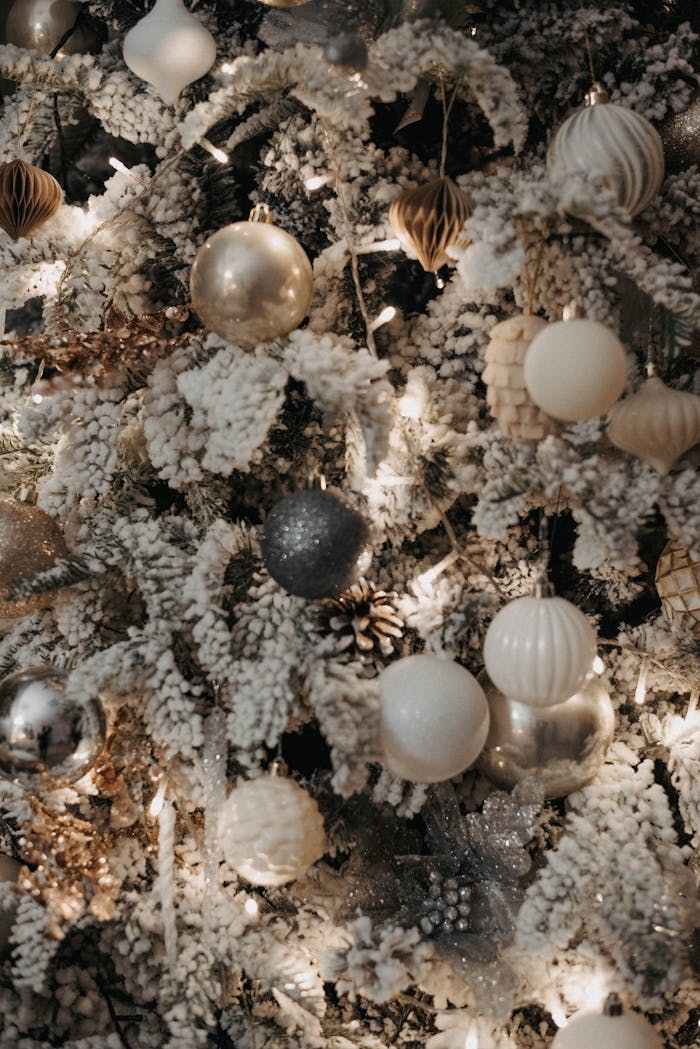 Luxurious Christmas tree with silver and white ornaments for festive decor.